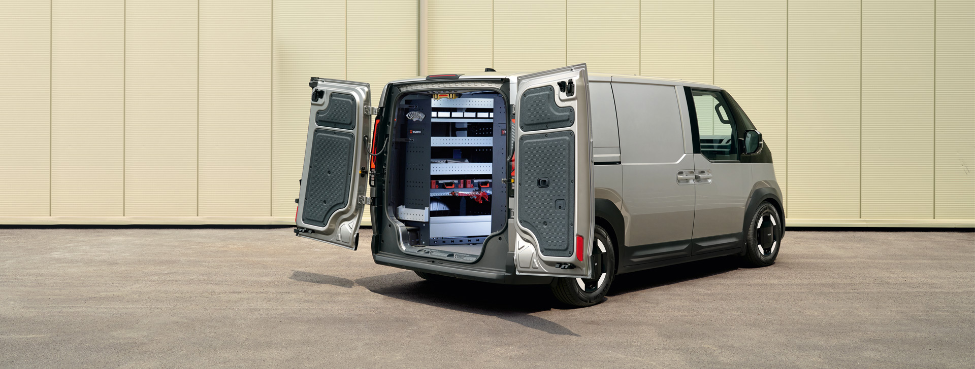 Der Kia PV5 Cargo in Heckansicht mit geöffneten Türen, eingebaute Würth-Regalsysteme sind sichtbar